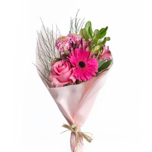 Buquê com rosas, gérberas e alstroemérias em tons de rosa, envolto em papel rosa claro


